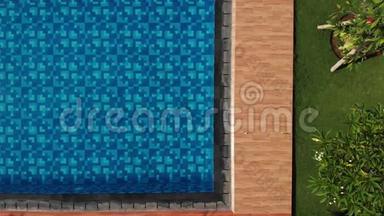 空中蓝色游泳池，有水晶般清澈的水，在阳光下俯视，<strong>水面</strong>有<strong>波纹</strong>。